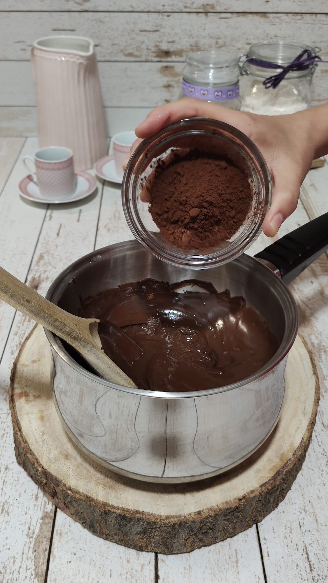 Añadiendo el cacao en polvo a la mezcla de chocolate y almíbar