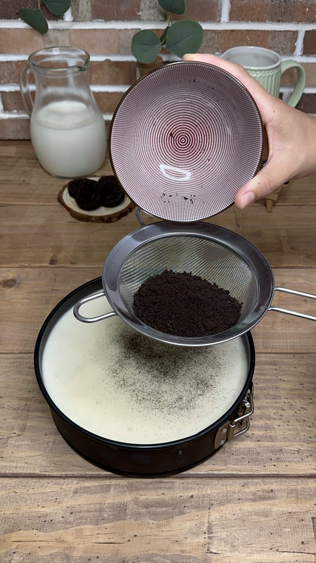 Espolvoreamos el polvo de Oreo reservado sobre la tarta ya fría Espolvoreamos el polvo de Oreo reservado sobre la tarta ya fría