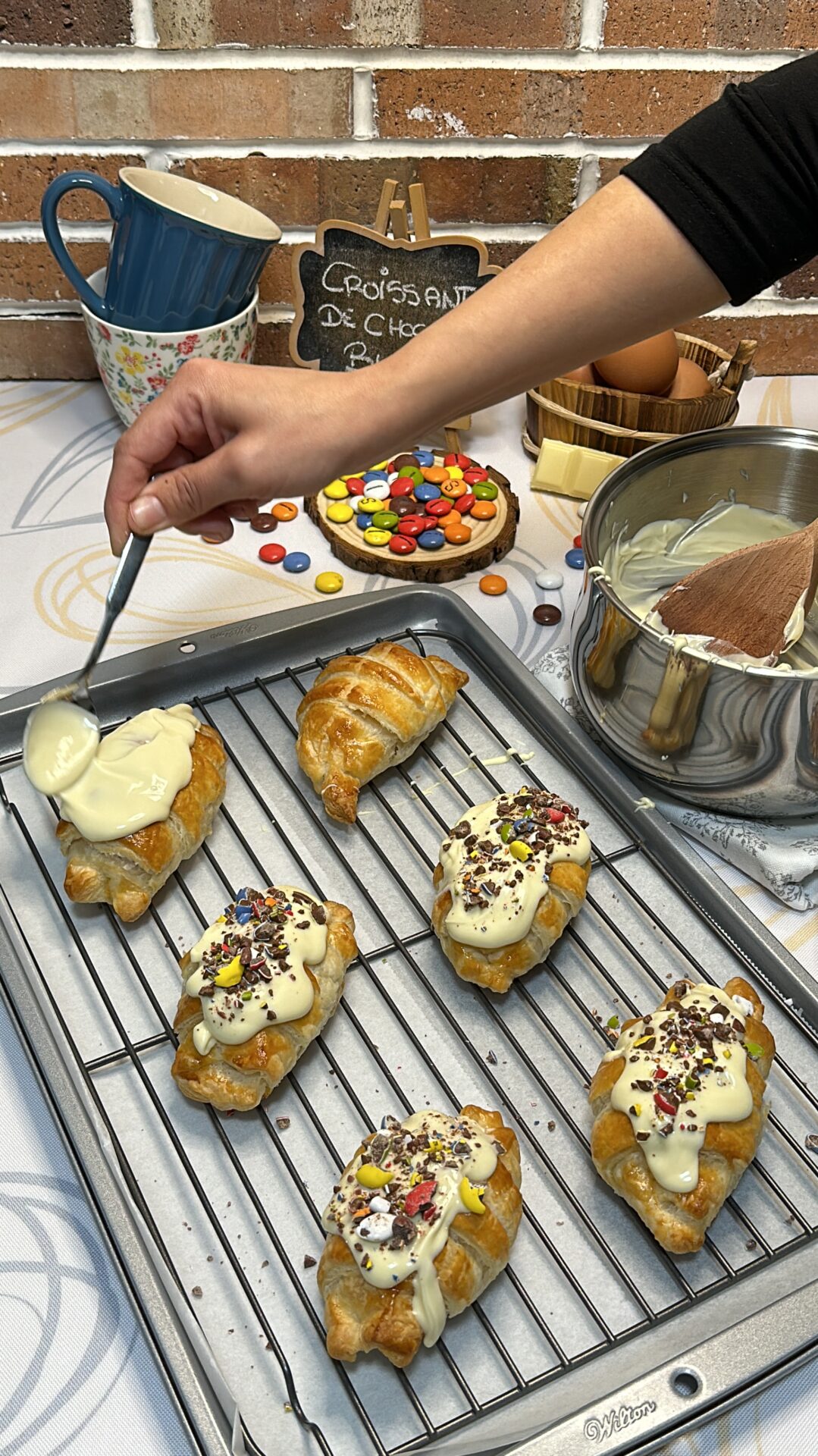 Decoramos los croissants con la cobertura y los lacasitos