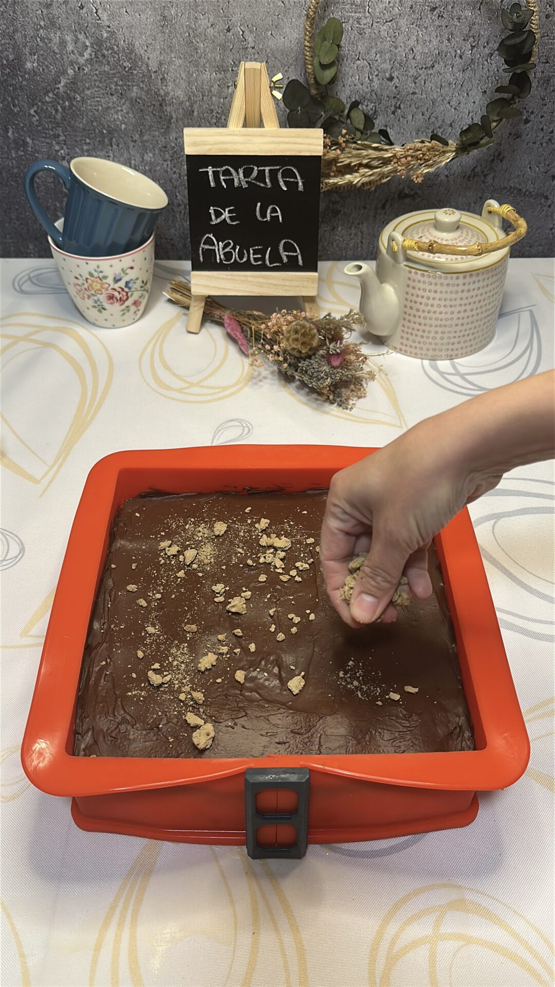 Espolvoreamos las migas de galleta sobre la tarta de la abuela