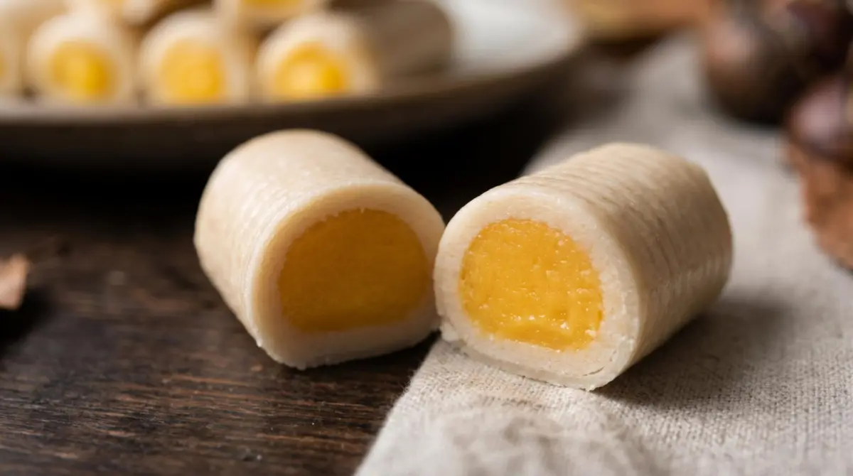 Hueso de santo cortado por la mitad mostrando el relleno de yema y el mazapán